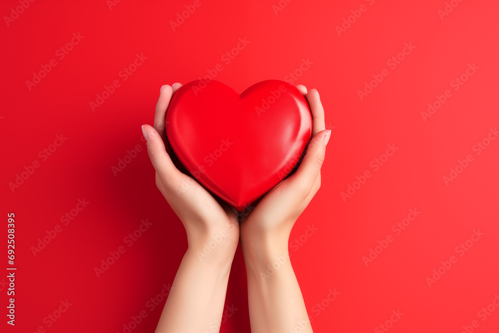 Close up on female hands holding a gift in a pink heart presents for valentine day, birthday, mother's day. Flat lay. Symbol of love. Valentines day background with a gift boxes on concrete board. Close up on female hands holding a gift in a pink heart presents for valentine day, birthday, mother's day. Flat lay. Symbol of love. Valentines day background with a gift boxes on concrete board.