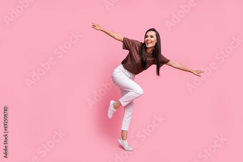 Full size photo of cheerful gorgeous girl hands wings dancing chilling empty space isolated on pink color background