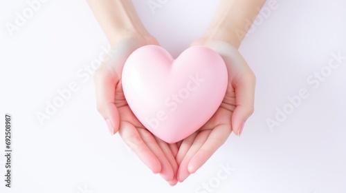 Volumetric pink heart holding a woman's hands close-up. Symbol of love. Happy Valentine's Day