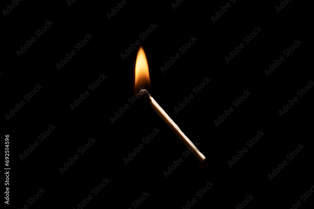 Lit falling match on a black background.