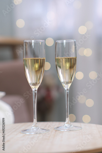Two glasses of Champagne on light background on caffee table in living room. Christmas home interior.