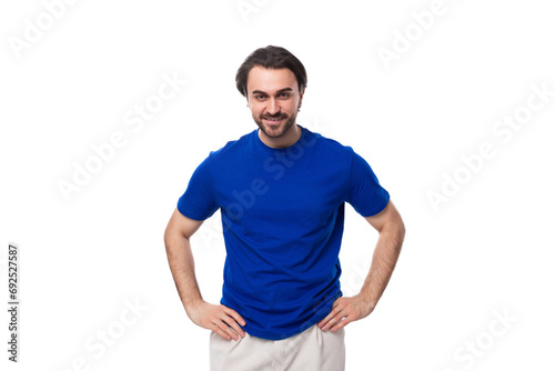young well-groomed brunette man with a beard dressed in a blue T-shirt among a white background