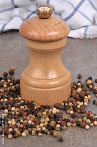 Moulin à poivre en bois avec du poivre en grains en gros plan