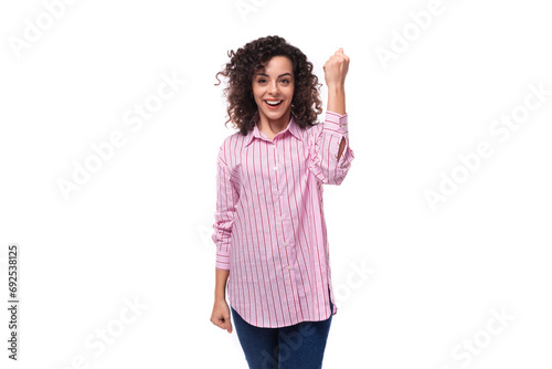young leader woman with curly hair dressed in a pink shirt and jeans