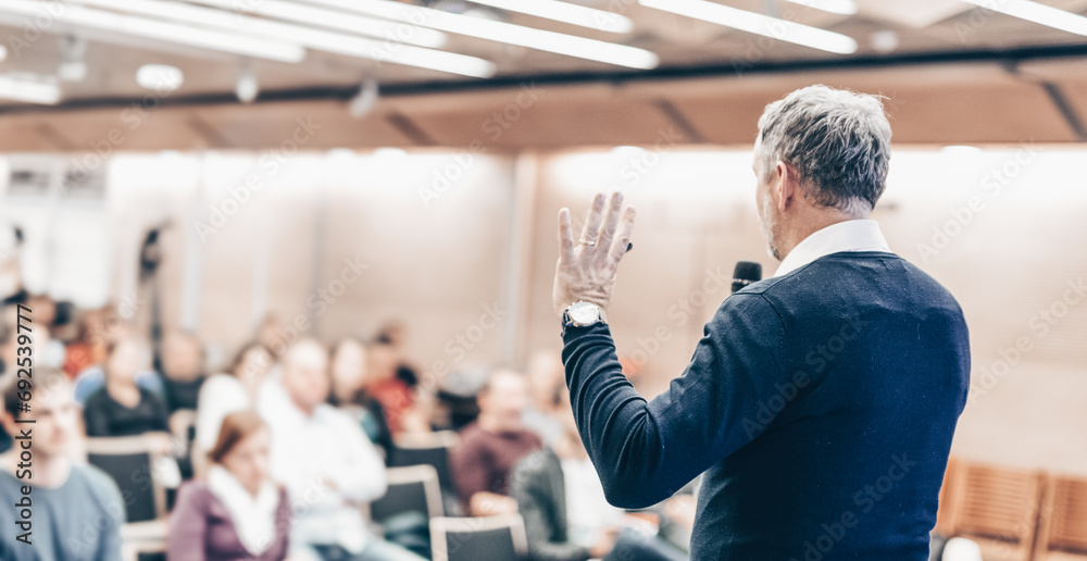Expert giving a talk on business conference workshop. Unrecognizable people in audience at the conference hall. Business and entrepreneurship event. Expert giving a talk on business conference workshop. Unrecognizable people in audience at the conference hall. Business and entrepreneurship event.