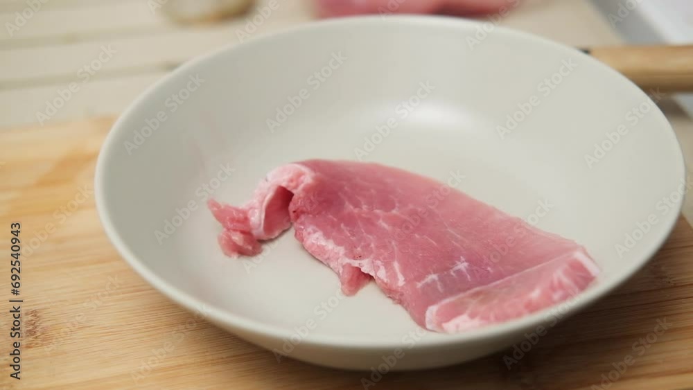 Placing raw meat chunks onto an empty plate Placing raw meat chunks onto an empty plate