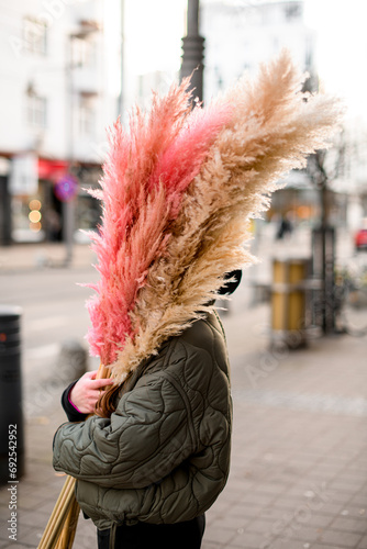 Voluminous fluffy bouquet in the hands of a cute girl in a black jacket