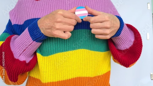 Woman hand holding small heart badge with LGBT flag colors closeup. Respect and support for community representants. Pride month photo