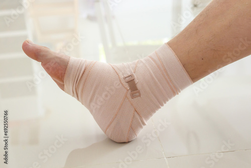 Man with ankle sprain elastic bandage for ankle injury and feeling pain © Piman Khrutmuang