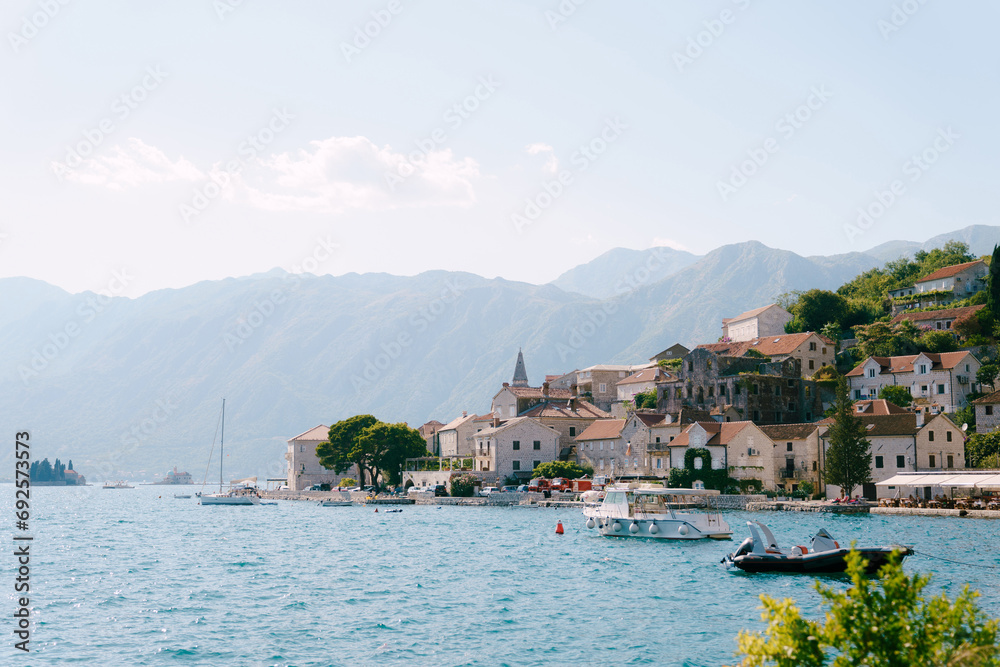 Excursion boats are moored off the coast of Perast against the backdrop of mountains. Montenegro