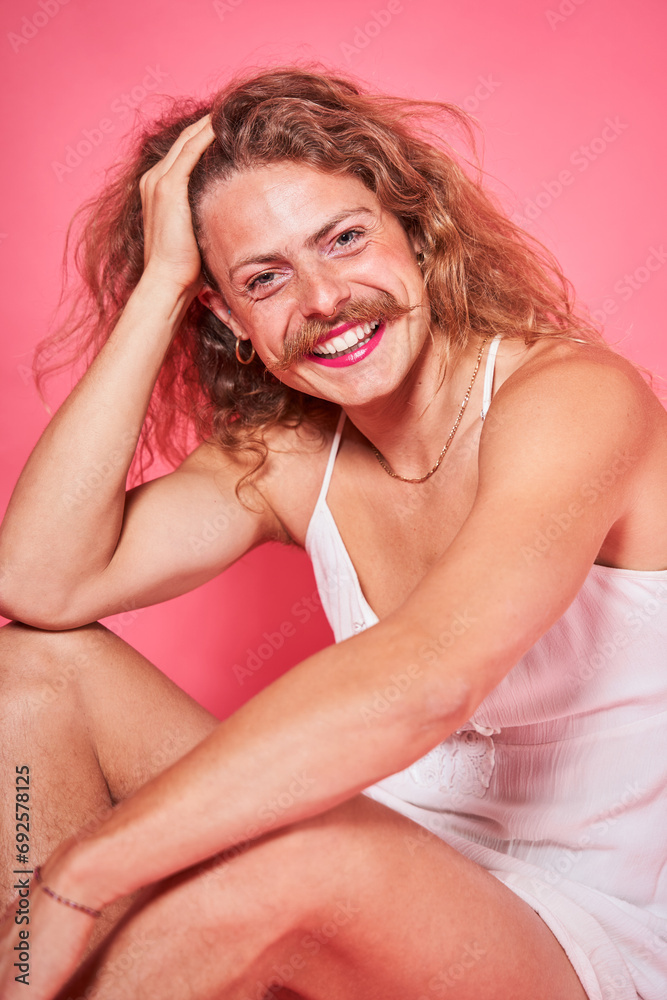 Androgynous man with makeup wearing dress looking at camera and flirting while posing Androgynous man with makeup wearing dress looking at camera and flirting while posing
