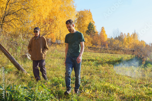 Two Man Grandfather and Grandson Enjoying a Leisurely Stroll in a Serene Natural Setting © Алексей Филатов