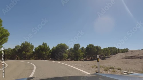 First person view, FPV, from dashcam of car driving mountain road from Calar Alto Observatory to Tabernas Desert in Almeria, Andalusia, Spain, Europe. Road trip in POV, with bright, sunny, clear sky photo