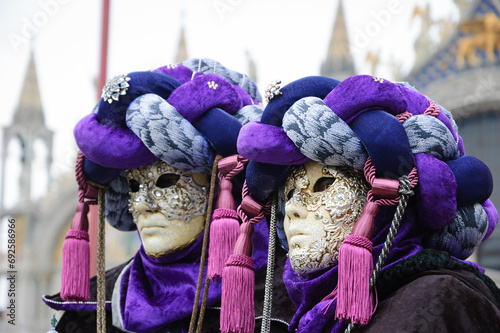 Carnival in Venice, Italy. Two masks in turbans at St Mark's Square  (St Mark's Basilica at background) during traditional Carnival. photo