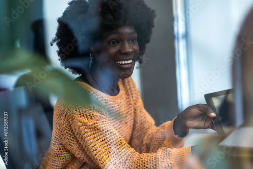 African American business woman sittingin her office with his tablet. photo