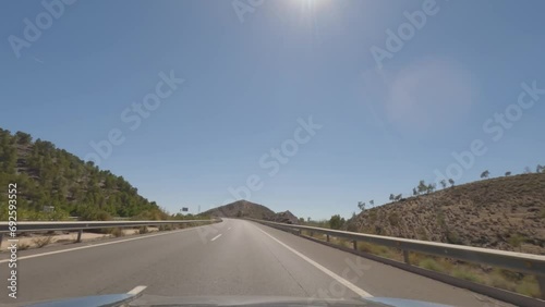 First person view from dashcam of car driving empty roads in the Tabernas desert in Almeria, Andalusia, Spain. Setting of spaghetti western films. Road trip video in POV, with bright, sunny, clear sky photo