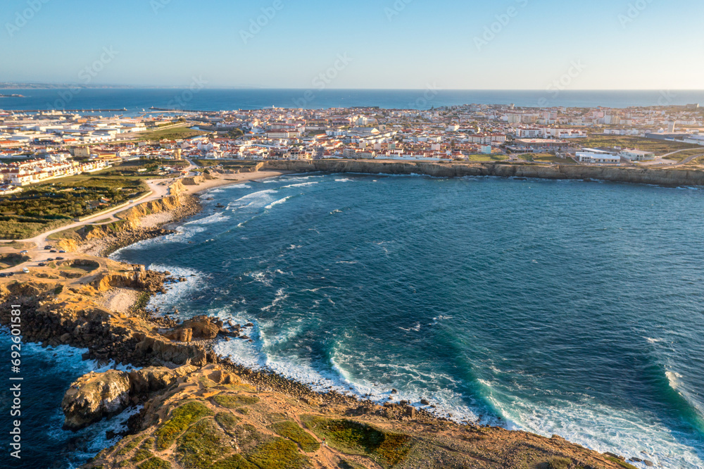 Drone view of waves in small bay by town of Peniche, Portugal