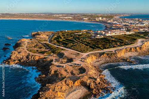 Peniche peninsula with high cliffs and ocean tide at sunset, Portugal