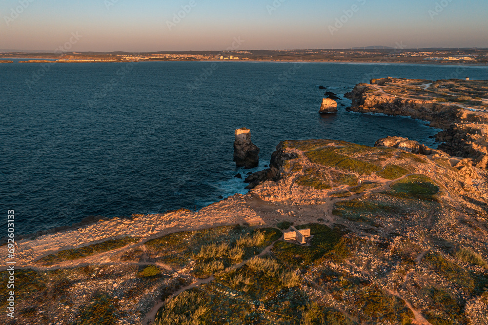 Aerial view of sunset over rocky cliffs and ocean bay, Peniche