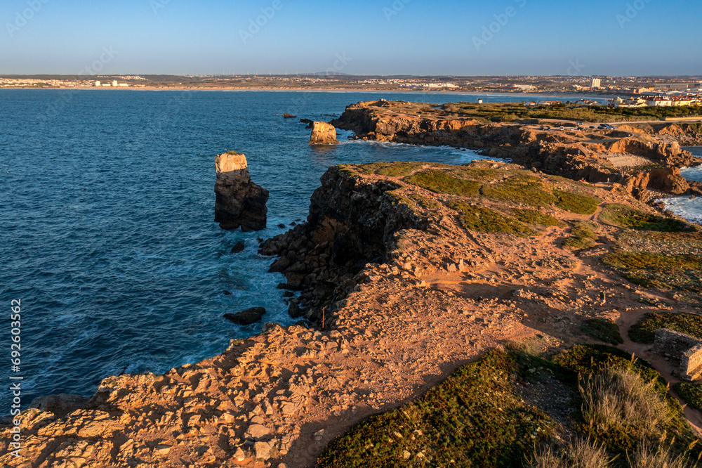 Aerial view of rocky cliffs and ocean bay, Peniche, Portugal at sunset