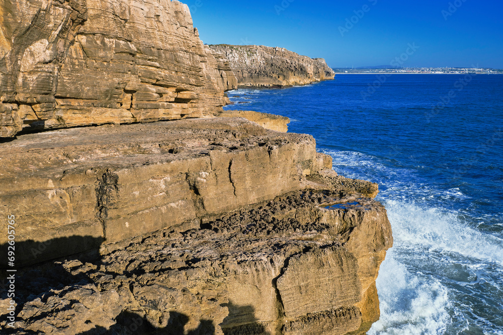Eroded rocks and sea waves of Atlantic ocean coast on sunny day
