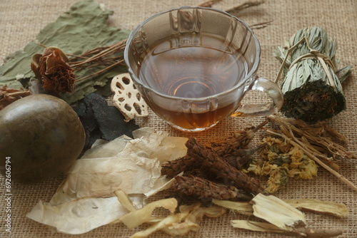 a glass cup of herbal juice or Jab-Liang juice with its herb ingredient. ingredients of Chinese herbal juice for internal body heat or internal hot relief. Jab-Liang juice. 