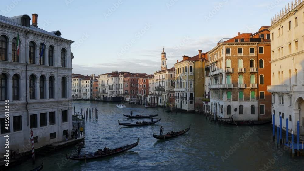 Venice canal with traditional gondola boats and tourist boats at sunset with historic colorful buildings on the margins, in Italy Venice canal with traditional gondola boats and tourist boats at sunset with historic colorful buildings on the margins, in Italy