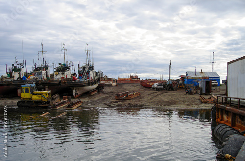 Industrial small fishing vessels on shore. Dry docking. Small port on Kamchatka