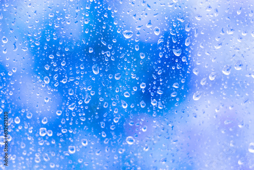 Water drops on glass on blue background-