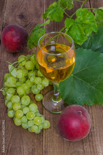 Glass of wine with green grapes and peaches
