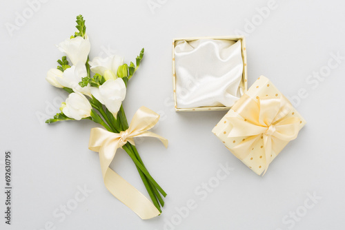 Open gift box  with fresia flower color background  top view