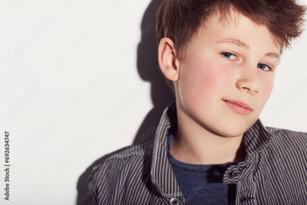 Teenager, portrait and boy with fashion in studio, white background with a smirk or smile. Cool, style and child with confidence in trendy clothes, outfit and pride in personality on backdrop Teenager, portrait and boy with fashion in studio, white background with a smirk or smile. Cool, style and child with confidence in trendy clothes, outfit and pride in personality on backdrop