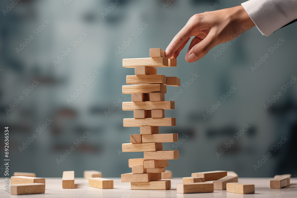 Jenga game, close-up of hands and a tower of wooden blocks collapsing. Jenga game, close-up of hands and a tower of wooden blocks collapsing.