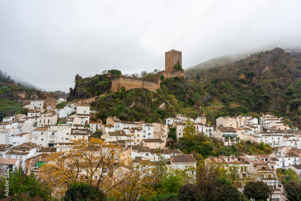 A castle in the mountain and on the bottom of the mountain small houses in a town in Spain