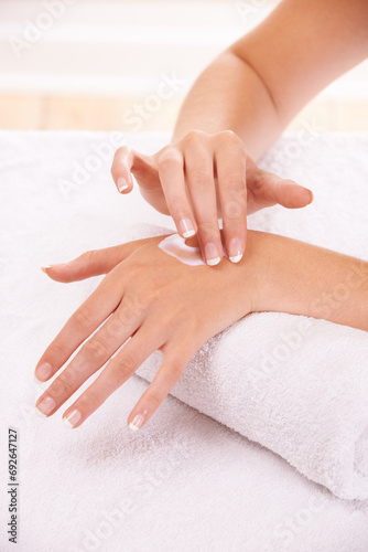 Skin, apply cream and hands in spa, closeup and massage on towel for care. Touch fingers, nails and woman on lotion treatment, natural cosmetics or dermatology moisturizer, beauty health or manicure