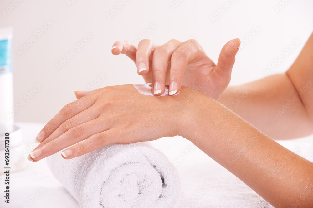 Touch skin, cream and hands in spa, closeup and massage on towel for care. Fingers, nails or person apply lotion in treatment, natural cosmetics or dermatology moisturizer, beauty health and manicure