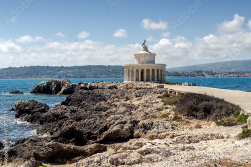 Old, stone lighthouse (Kefalonia Island, Greece) against the backdrop of the sea and mountains