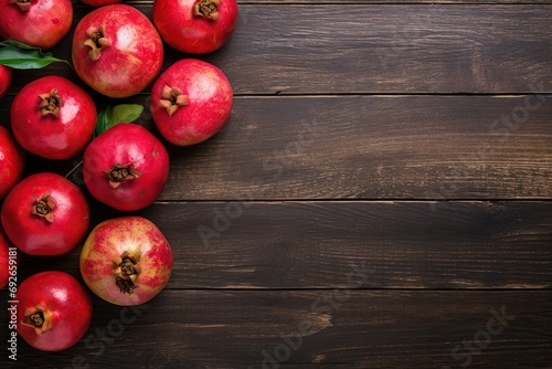 Fresh ripe pomegranate with green leaves on wooden background