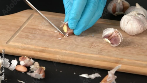 Peeling garlic on a dark table.