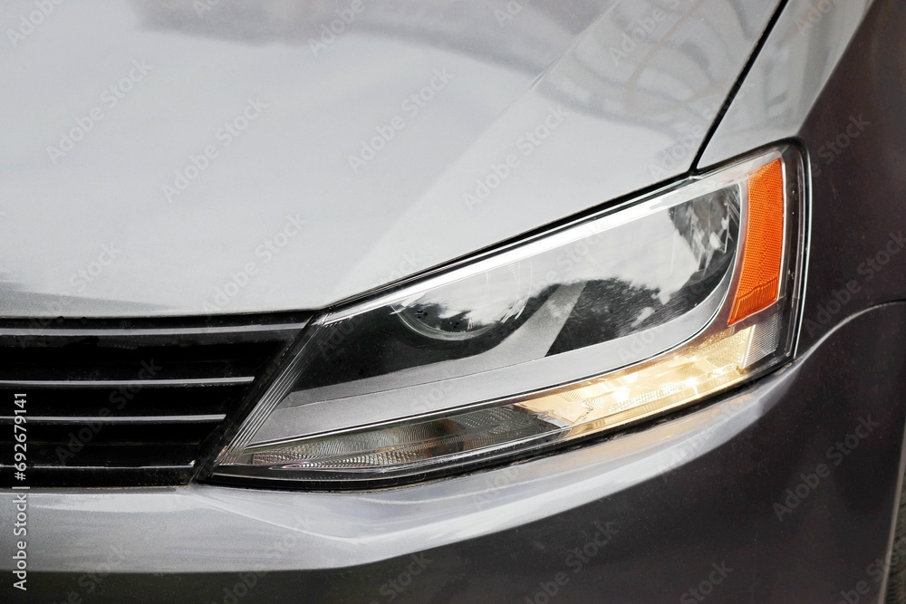 Image of the left headlight of a passenger car.