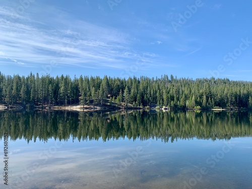 a small lake with some trees in the background and sky