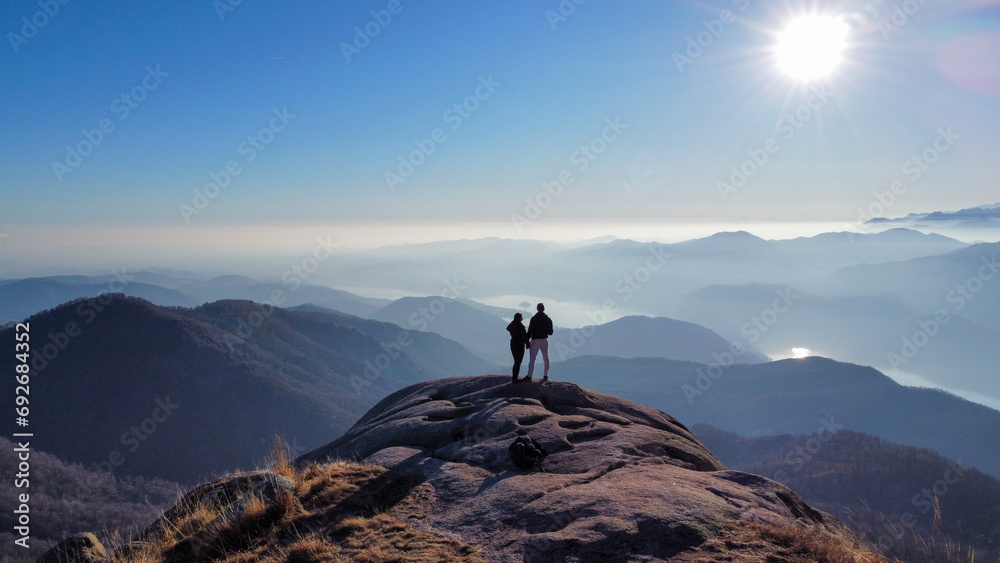 Landscapes with mountains and lakes. Area view with shades of colors, blue water and green meadows. Couple in love