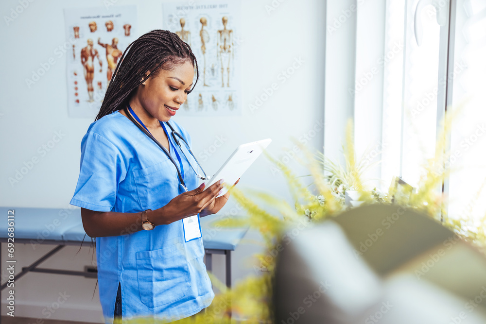Female nurse using her digital tablet while standing in the consultation. Female medical intern with tablet computer. Female surgeon using digital tablet in front of computer at clinic Female nurse using her digital tablet while standing in the consultation. Female medical intern with tablet computer. Female surgeon using digital tablet in front of computer at clinic