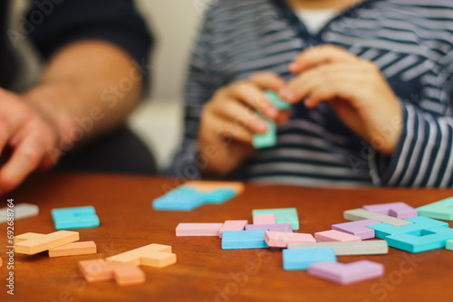 logical multi-colored toys on the table and a silhouette of a boy in the background