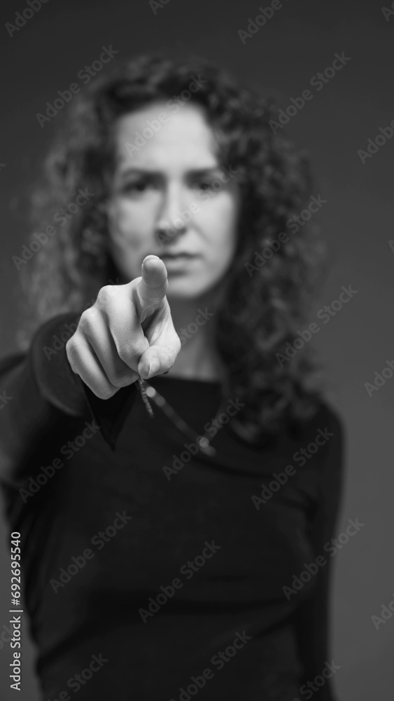 Woman accusing viewer by pointing finger toward camera in dramatic monochromatic black and white, vertical video. Person saying YOU with hand Woman accusing viewer by pointing finger toward camera in dramatic monochromatic black and white, vertical video. Person saying YOU with hand