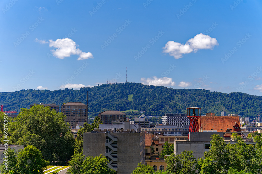 Scenic view of skyline of Swiss City of Zürich with skyscrapers and local mountain Uetliberg in the background on a sunny hot summer day. Photo taken July 20th, 2023, Zurich, Switzerland.
