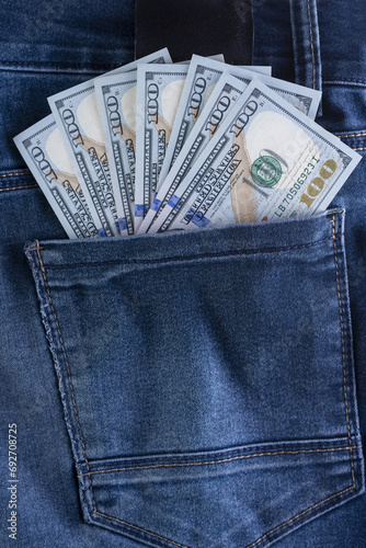 many 100 dollar bills coming out of the back pocket of his jeans