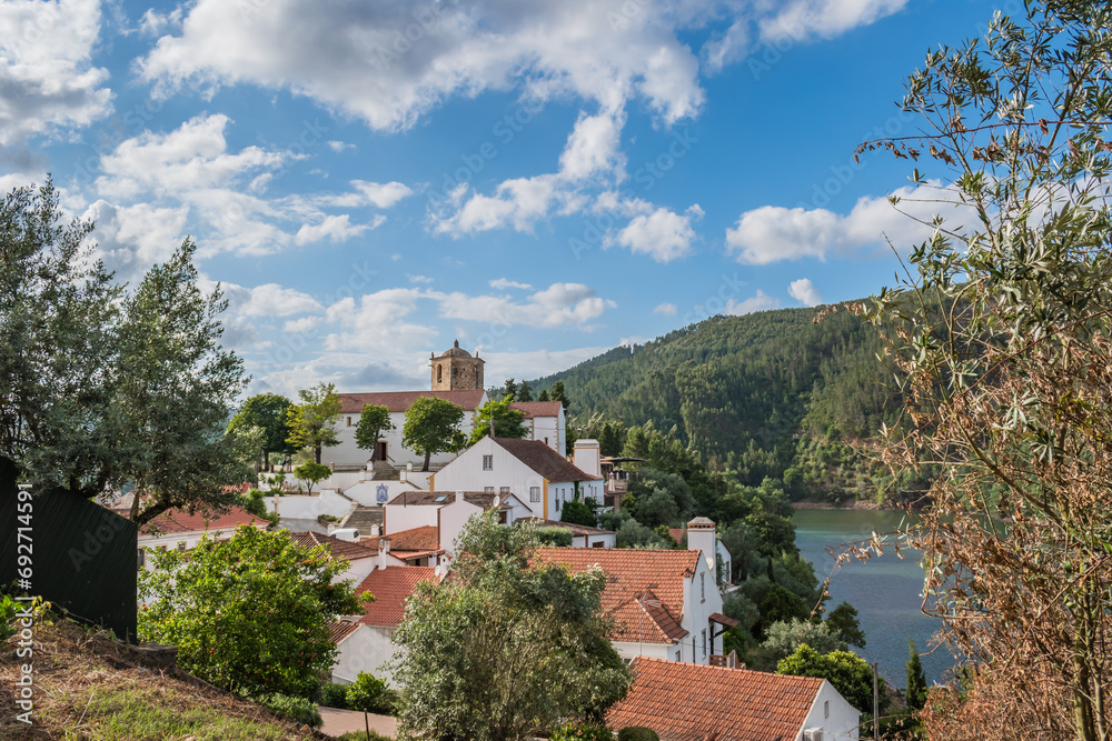 Landscape with houses next to the river Zêzere and the templar tower of Dornes, PORTUGAL