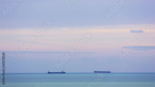 Sunset view at Mersin, Turkey with container ships anchored off coast. Container ship silhouettes against Mediterranean sunset. Container ship awaiting port entry near Turkish coastline photo