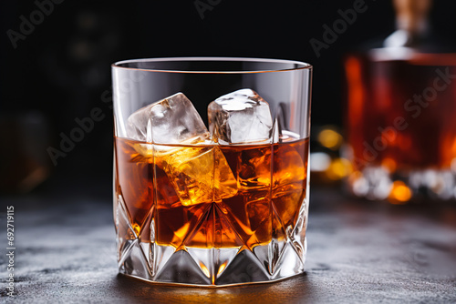 Glass of whiskey with ice on a dark romantic background.